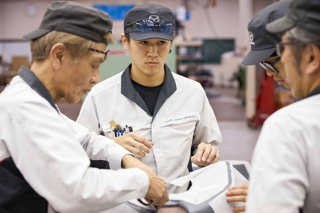 藤木（左）をはじめとするベテランモデラーのアイディアに耳を傾ける安富（中央）