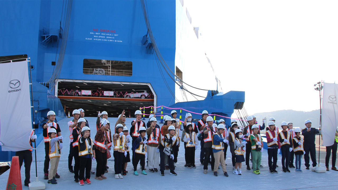 巨大な専用船とともに、笑顔の記念撮影