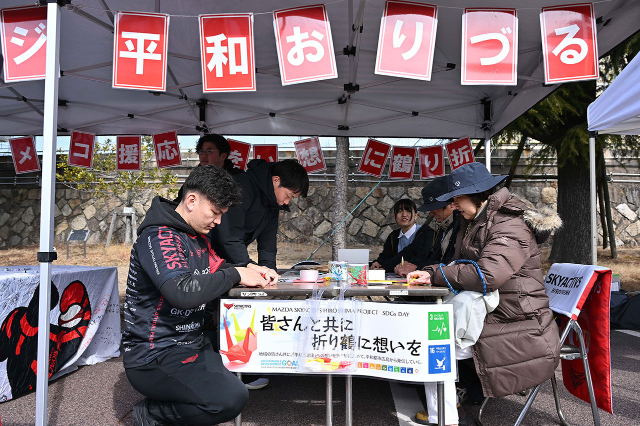 マツダスカイアクティブズ広島のラグビー試合会場でお客さまと選手が一緒に鶴を折りました